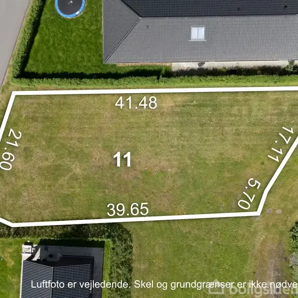 Grønt areal med hvide markeringer viser matrikelnummer 11. Målene 41.48, 21.60, 39.65, 17.17 og 5.70. Omgivet af veje og huse. Tekst: "Luftfoto er vejledende. Skel og grundgrænser er ikke nødvendigvis korrekt."