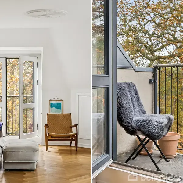Stue med stor sofa og lænestol foran åbne franske døre. Udenfor ses en altan med en stol beklædt med pels, omgivet af efterårsfarvede træer.