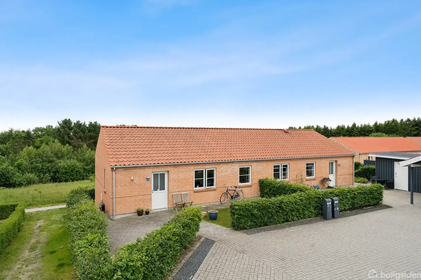 Rødstenshus med altan, terrasse og skovudsigt