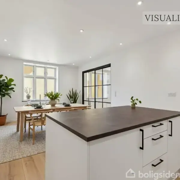 Et køkken- og spiseområde med en sort bordplade på en hvid køkkenø; en spisebordgruppe i baggrunden, omgivet af planter og kunst. Tekst: "VISUALISERING".