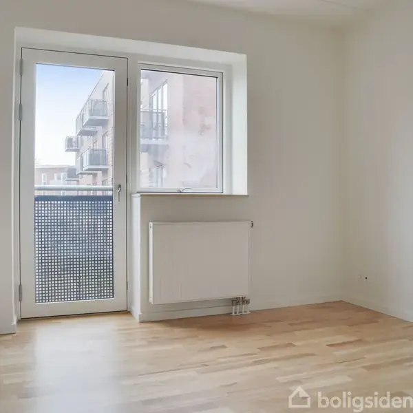 Et tomt rum med trægulv har en dør og vindue mod en altan. Bygningsfacader ses udenfor. En radiator er under vinduet. Ingen tekst er synlig.