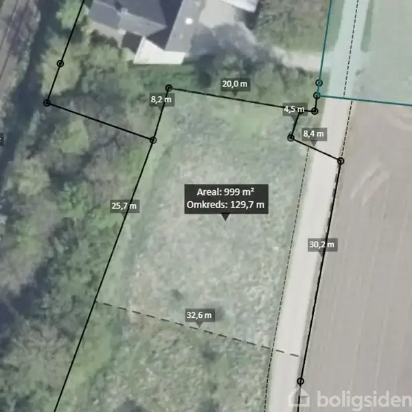 Kort viser en grund med markerede grænser. Tekst viser areal og omkreds: "Areal: 999 m², Omkreds: 129,7 m." Omgivet af vej på højre side og vegetation til venstre.