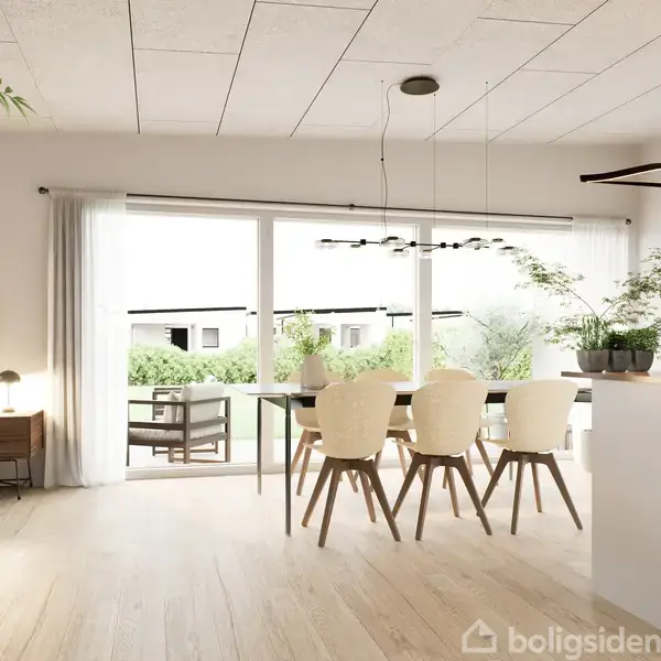Et bord med champagneflaske og glas står på en terrasse. Bakken har frugt. To sofaer flankerer bordet, omgivet af en velholdt græsplæne og hæk, under en åben himmel.
