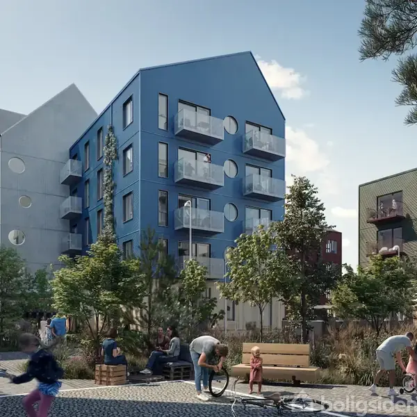 Blå og grå lejlighedsbygninger med runde altaner står i en moderne bypark. Mennesker sidder på bænke, cykler og leger, omgivet af træer og buske i solskin.