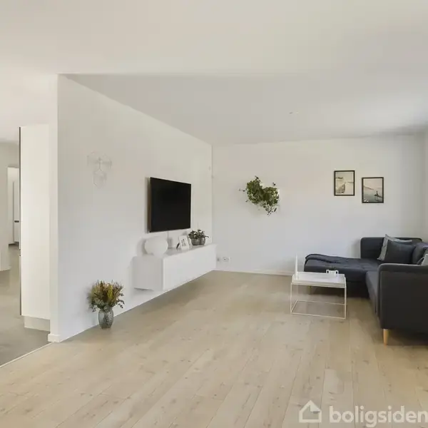 Køkken med hvide skabe og grå fliser. I baggrunden står et spisebord med hvide stole. På væggen ses teksten "LIVE! BELIEVE! HOPE" og en vægplakat af et træ.
