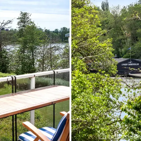 En altan med træbord og stole står mod en sø omgivet af træer. Til højre ses "Lyngby Dameroklub" nær vandkanten omringet af frodig vegetation.