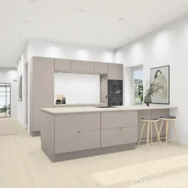 Køkken med grå køkkenø og to høje stole. Vægbillede af en fugl; store vinduer til haven. Lyse vægge og gulve skaber en rummelig og lys atmosfære.