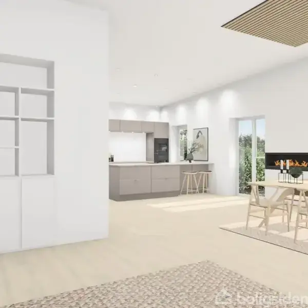 Et moderne køkken-alrum med en køkkenø i midten. Bord og stole står ved de store vinduer, der giver udsigt til en have. Indbyggede reoler ses til venstre.