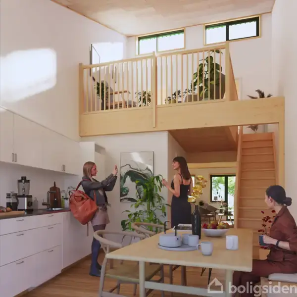 To personer taler i et moderne køkken med hvide skabe. Trappen fører op til en hems med planter. En tredje person sidder ved et bord i nærheden.