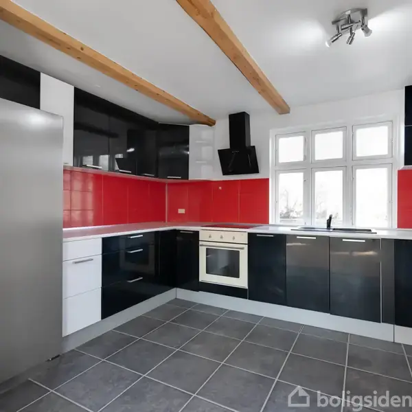Køkken med sorte og hvide skabe arrangeret i en L-form, rød backsplash, rustfrit stål køleskab, ovn og komfur i et moderne rum med grå gulvfliser og synlige træbjælker.