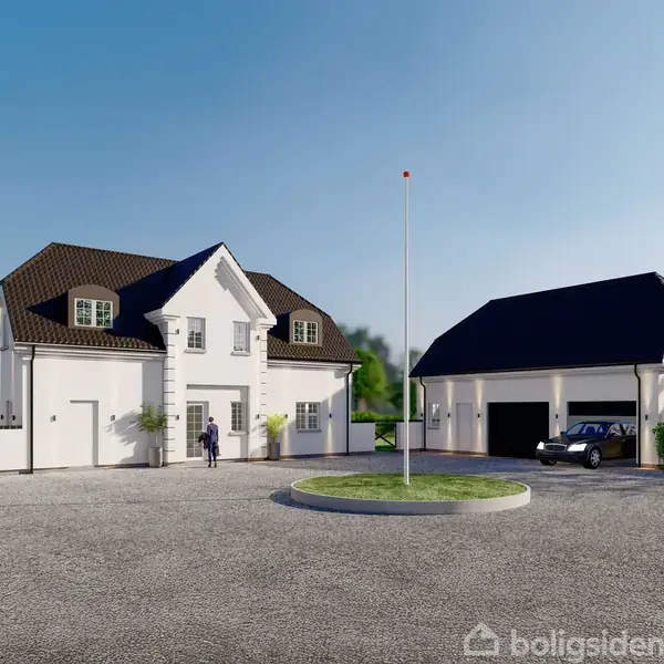 Et hvidt to-etagers hus med mørkt tag står ved siden af en matchende garage. En person går mod huset. Omkring er der grønne buske og træer under en blå himmel.