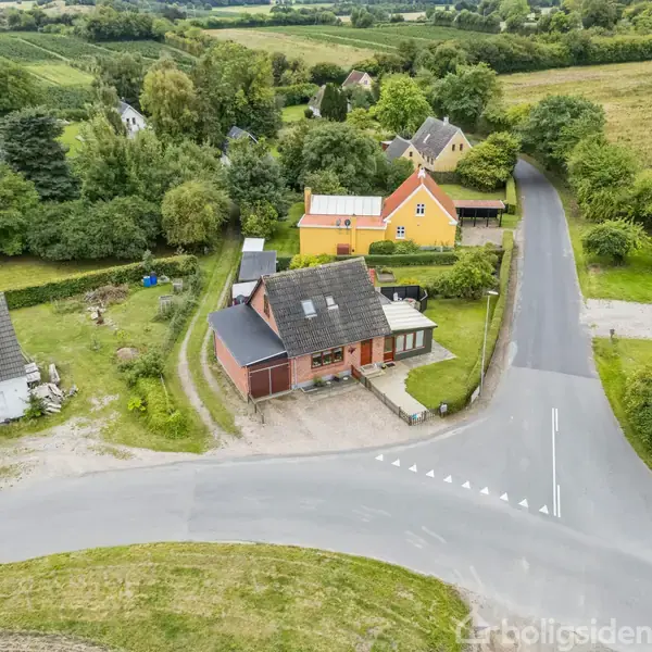 Plantegning viser en bolig med stue, udestue, køkken, bryggers og bad. En entré forbinder rummene. Der er en terrasse udenfor køkkenet. Målene er angivet i meter for hvert rum.