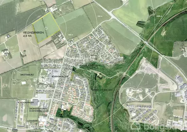 Luftfoto kort viser beboelsesområde med marker og veje. Tekst viser "Vieshøjparken 4,8 ha," "Daginstitution Rønnishave," "Roskilde Bank," og "Idrætsanlæg." Grønne områder og marker omgiver byen.