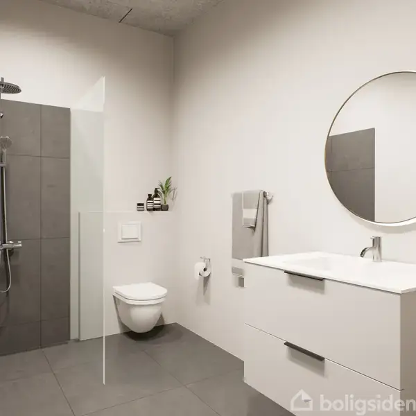 Et moderne badeværelse med bruser til venstre, væghængt toilet i midten, og en hvid vask med stort rundt spejl til højre. Der er en grøn sæbedispenser på vasken.