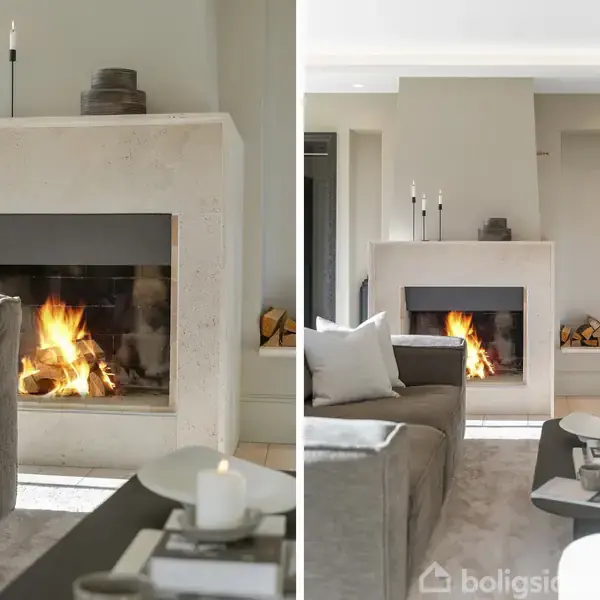 Pejs med ild brænder i elegant stue. Pejsen er flankeret af stearinlys og dekorationer, mens komfortable sofaer og et sofabord skaber en indbydende atmosfære.