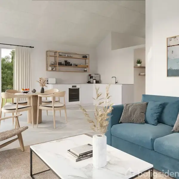 Blå sofa med puder står i stue, vendt mod hvid marmorbord med vase; spisebord og stole bagved. Hjørnekøkken med ovn- og hyldeopbevaring; glasdør til have. Rummelige, lyse omgivelser.