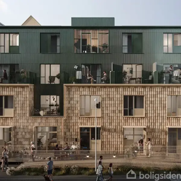 En moderne bygning med fire etager, hvor folk på altaner nyder udendørsmøbler. Facaden har en blanding af grønne og murstenslignende materialer. Gaden foran er livlig med forbipasserende.