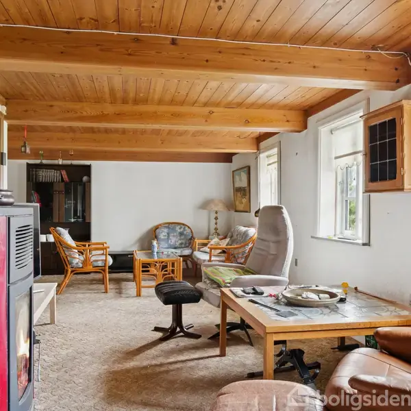 Stue med trægulv og træloft, hvor der står lænestole og et sofabord på tæppe. I hjørnet er en brændeovn. Væggene har store vinduer og en lille træhylde.